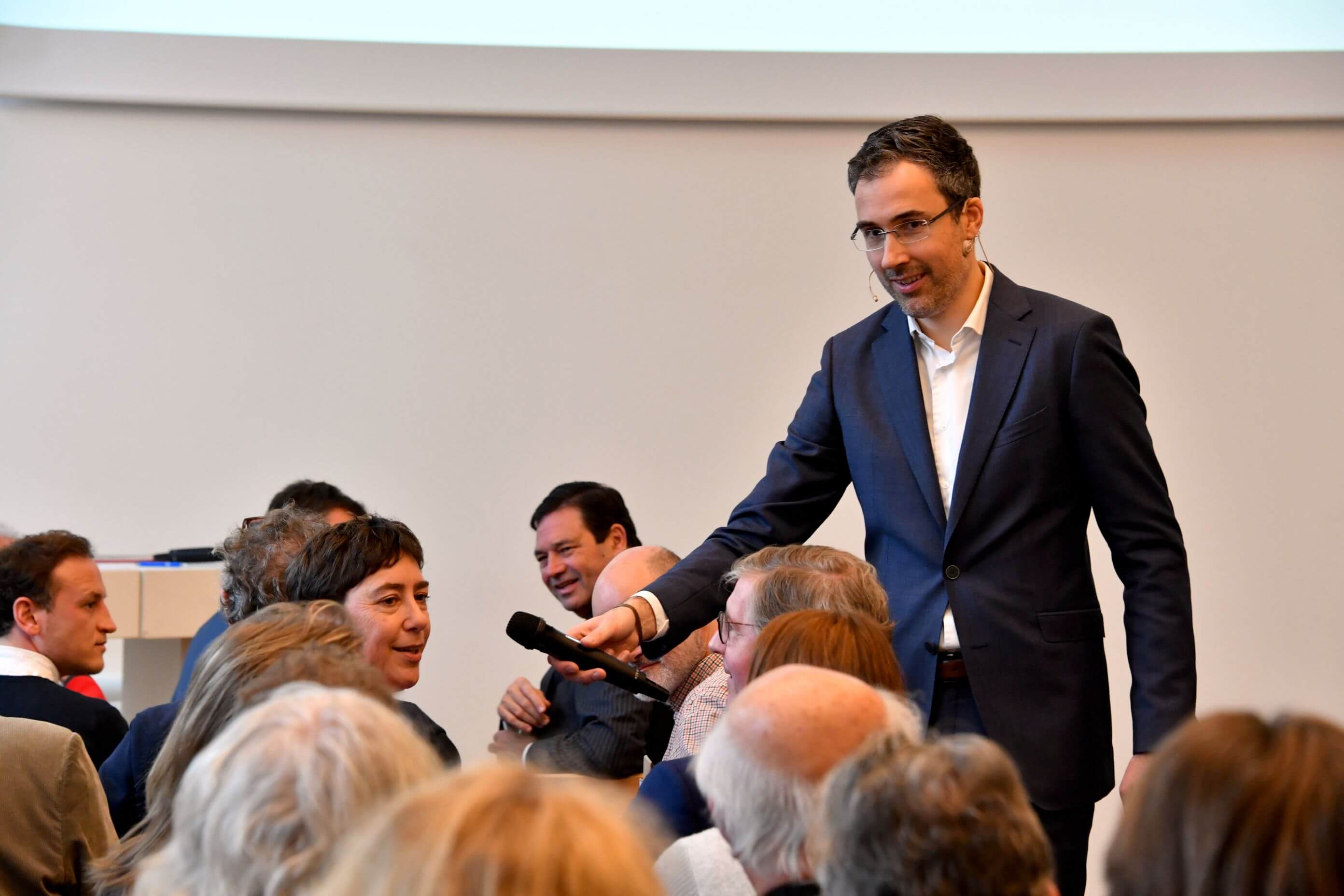 Imre Végh delivering a leadership training session with microphone, engaging with an audience during a presentation